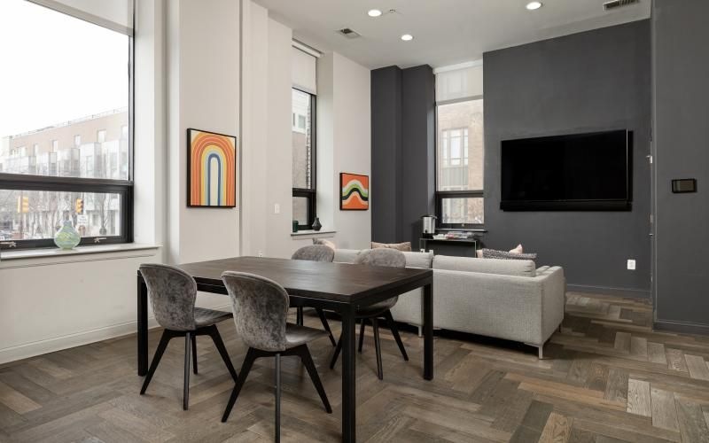 a clubroom with a tv, couch, table and chairs