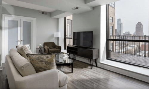 Furnished living room with balcony and expansive Philadelphia skyline views